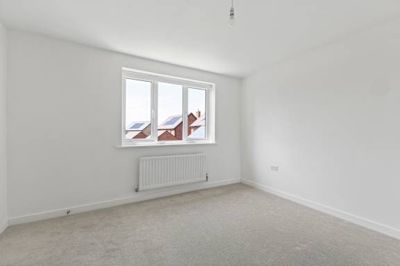 A room with a window and a radiator on the wall.