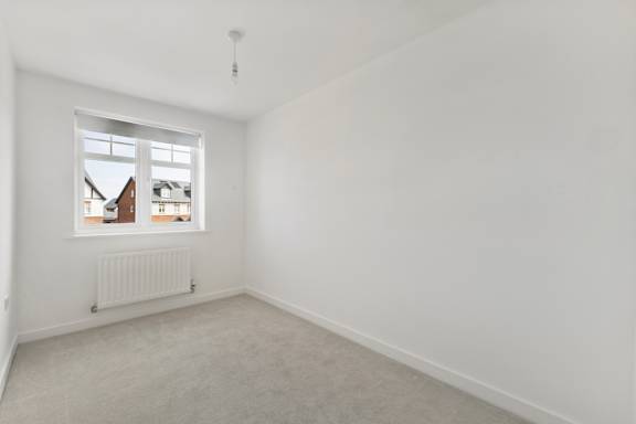 A white room with a window and a radiator.