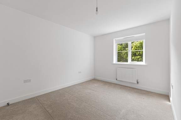 A room with a window and a radiator on the wall.