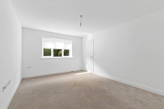A room with a window and carpeted floor.