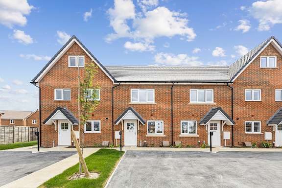 A row of houses with a tree in front of the first one.