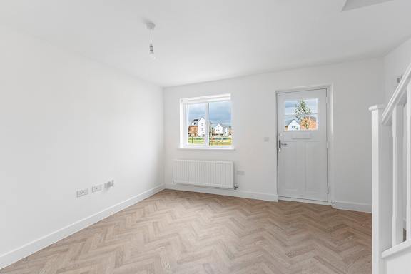 A room with a window showing a view of houses and trees outside.