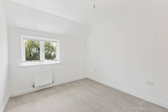 A room with a window and a radiator on the wall.