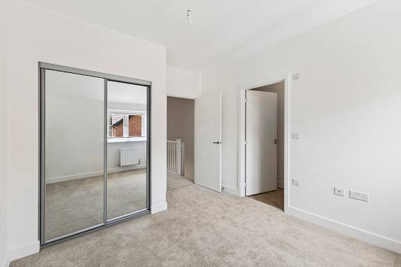 A room with a glass door leading to a balcony.