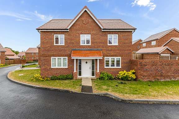A red brick house with a white door and windows.