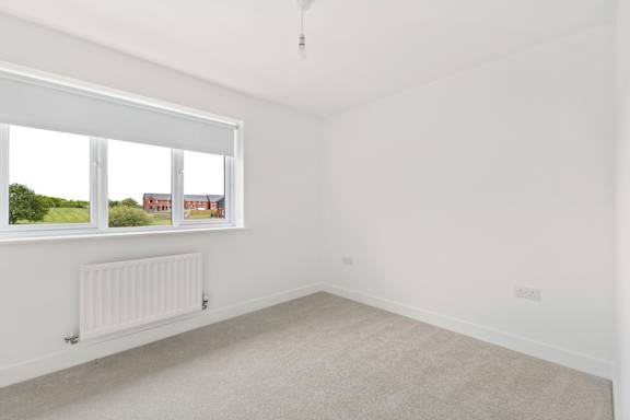 A room with a window and a radiator on the wall.