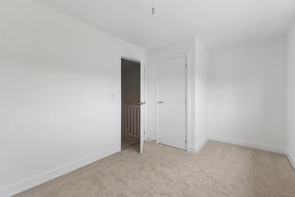A white room with a carpeted floor and two doors.