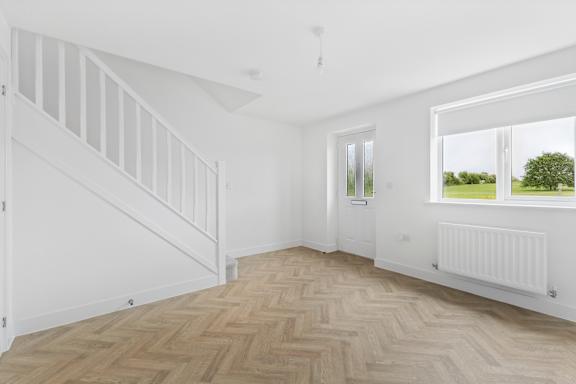 A room with a wooden floor and white walls.