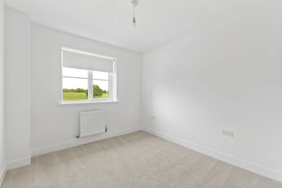 A room with a window and a radiator on the wall.