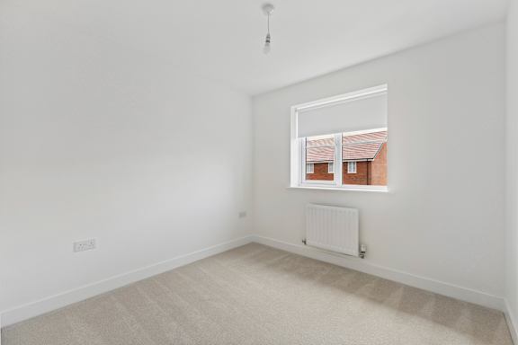 A room with a window and a radiator on the floor.