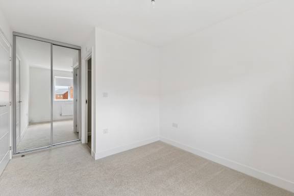 A room with a carpeted floor and a sliding glass door.