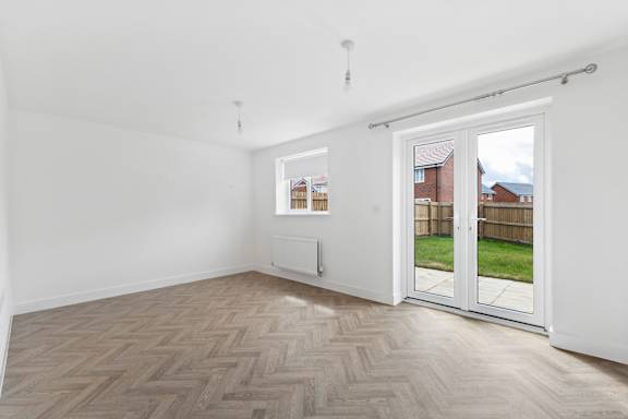 A room with a wooden floor and a sliding glass door.