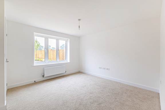 A room with a window and a radiator on the wall.