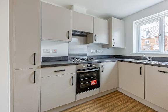 A kitchen with a stove, oven, and cabinets.