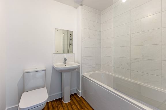 A white toilet sits next to a sink in a bathroom.
