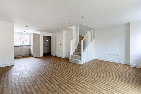 A room with wooden floors and a staircase.