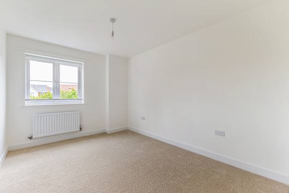 A room with a window and a radiator on the wall.