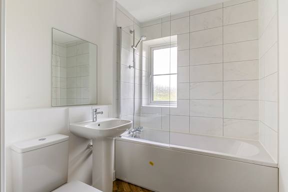 A white bathroom with a sink, toilet, and tub.