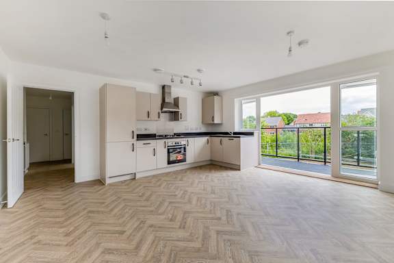 A spacious kitchen with a herringbone parquet floor.