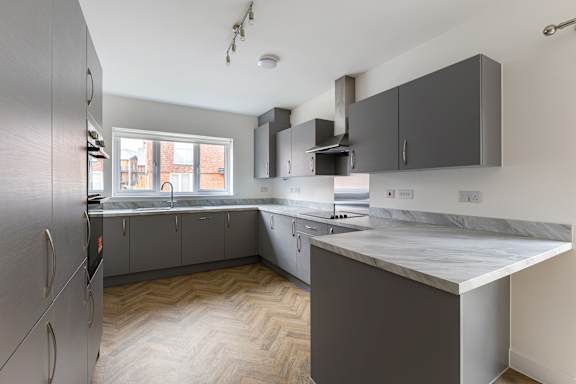 A kitchen with a refrigerator on the left and a countertop on the right.