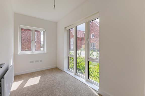 A room with a window and a door leading to a garden.