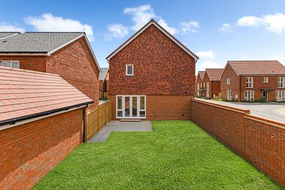 A red brick house with a green lawn in front.