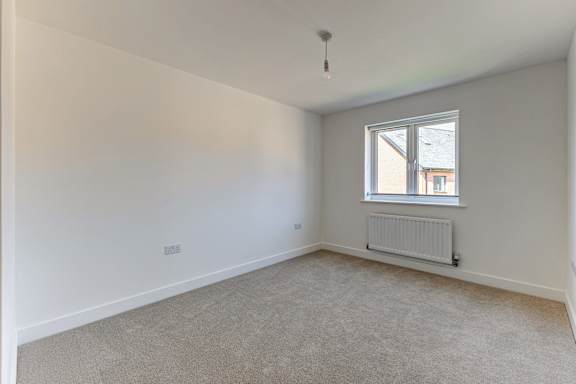 A room with a window and a radiator on the floor.