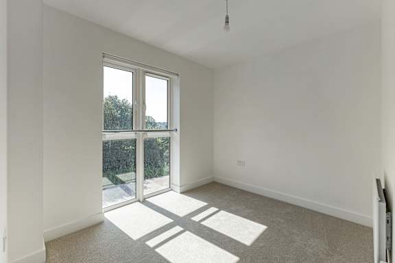 A room with a large window and sliding glass doors.