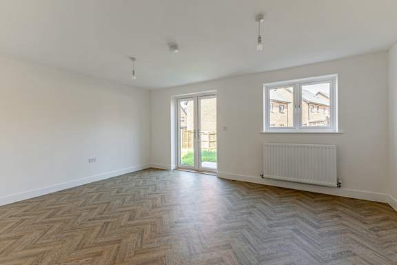 A room with a wooden floor and a window.