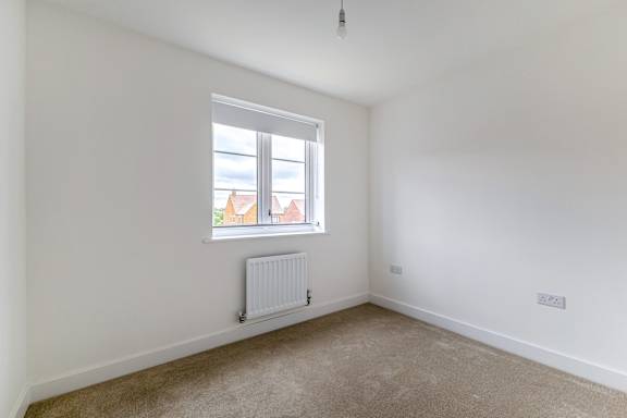 A room with a window and a radiator on the wall.