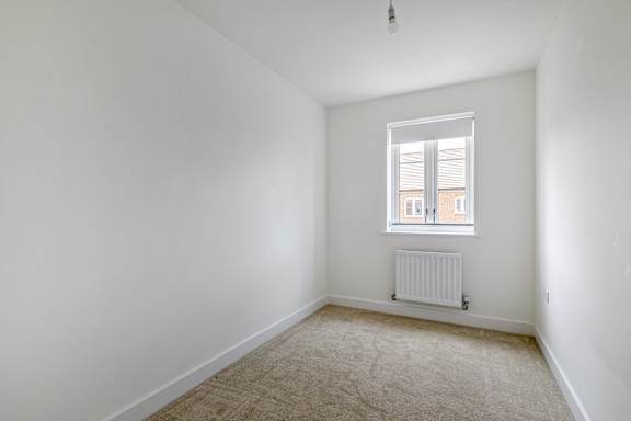 A room with a window and a radiator on the wall.