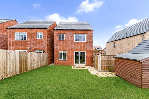 A red brick house with a green lawn in front.
