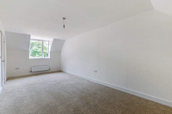 A room with a carpeted floor and a window.