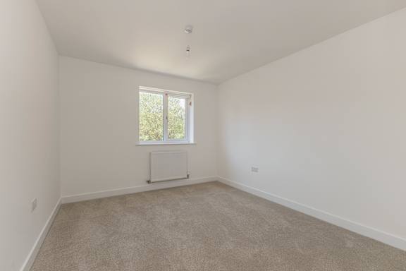 A room with a window and a radiator on the wall.