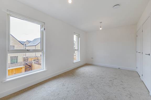 A room with a large window and a view of a building across the street.
