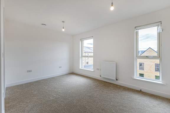 A spacious room with a window and a radiator.