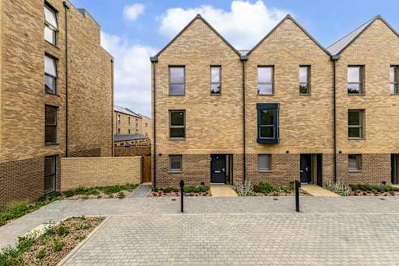 A brick building with a courtyard in front.