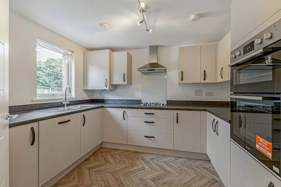 A kitchen with white cabinets and a black stove top oven.