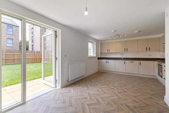 A kitchen with a herringbone patterned floor and white walls.