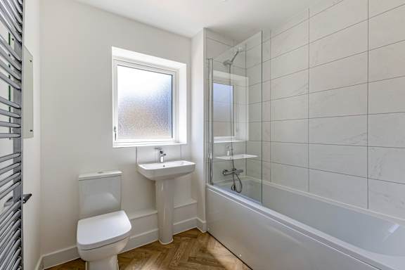 A white toilet sits next to a sink in a bathroom.