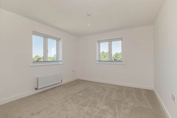 A room with a carpeted floor and two windows.