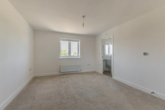 A room with a window and a radiator on the floor.