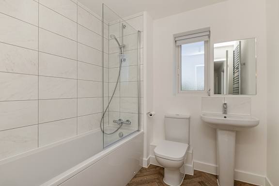A white bathroom with a toilet, sink, and tub.