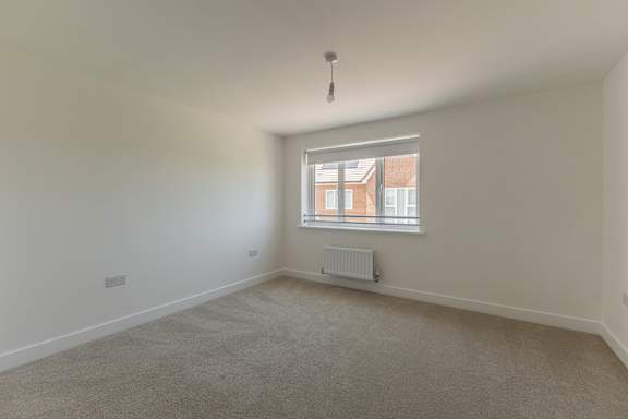A room with a window and a radiator on the wall.