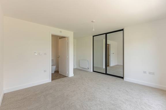 A large, empty room with a carpeted floor and white walls.