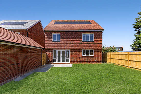 A red brick house with a white door and windows.