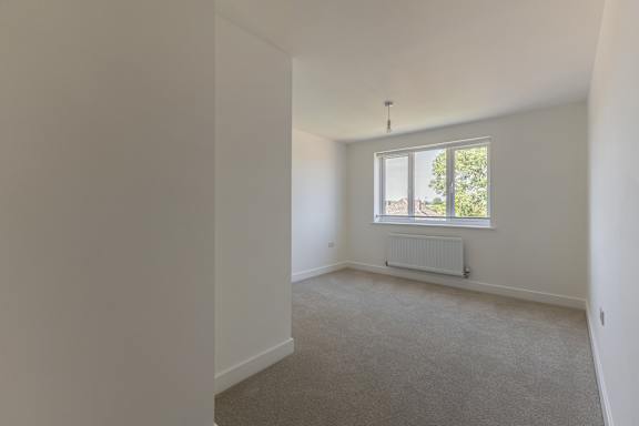 A room with a window and a radiator on the wall.