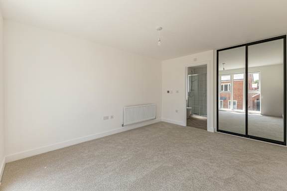 A room with a carpeted floor and a sliding glass door.