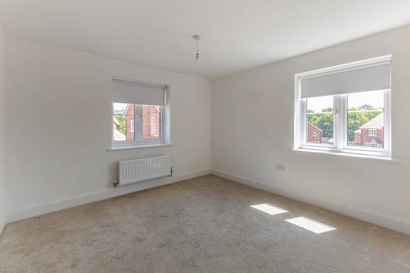 A room with a window and a radiator on the wall.