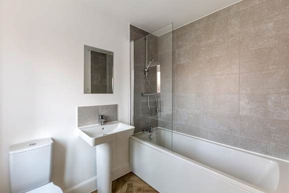 A bathroom with a toilet, sink, and bathtub.